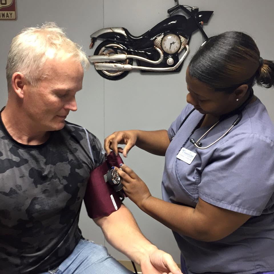 A FICOM staff member takes a blood pressure reading
